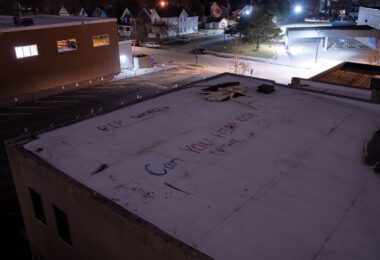 "RIP George" "Can you hear us now!" written on a rooftop of a building across from the Minneapolis Police Third Precinct. The Third Precinct was burned during unrest over the May 25th murder of George Floyd.