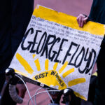 A protester holds up a George Floyd Rest In Power sign at a march during the Derek Chauvin murder trial in Minneapolis.