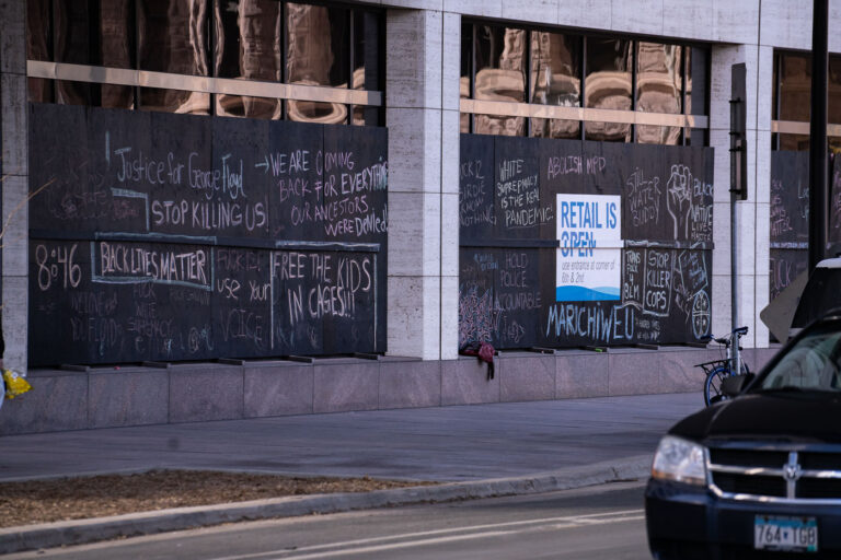 Justice for George Floyd chalk on boards 5 Boards on the US Bank Building with chalk writing on it.