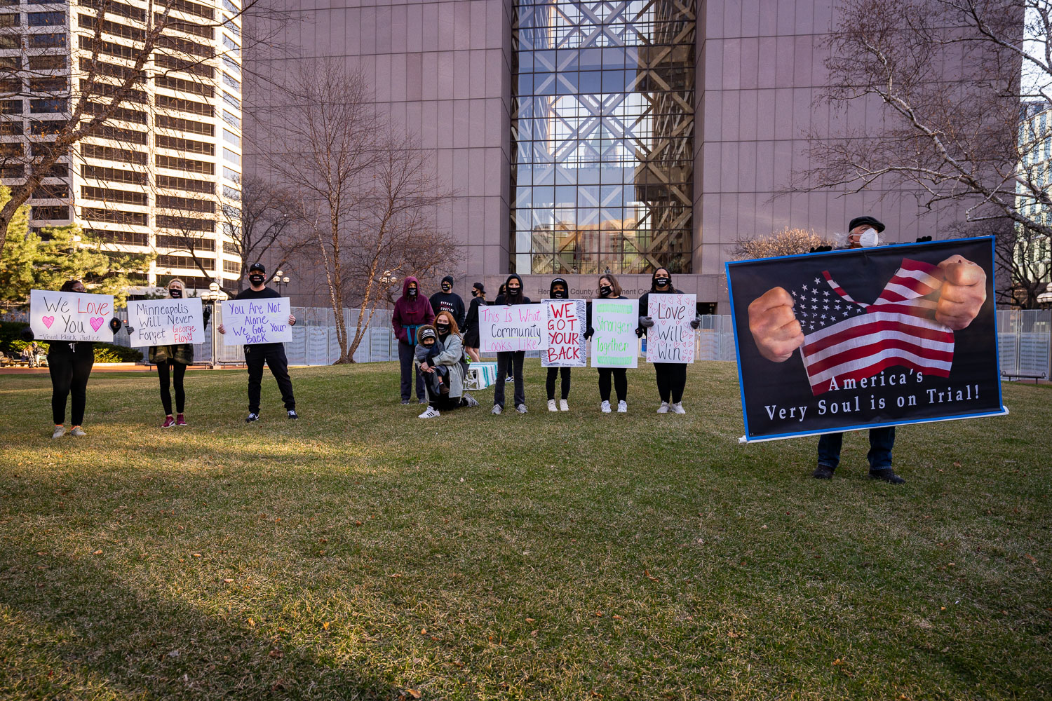 March 29, 2021 - Minneapolis -- Prortesters hold up signs outside the Hennepin County Government Center as opening statements in the Derek Chauvin murder trial begin.
