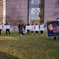 Protesters hold up signs outside the Hennepin County Government Center as opening statements in the Derek Chauvin murder trial begin.