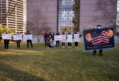 Protesters hold up signs outside the Hennepin County Government Center as opening statements in the Derek Chauvin murder trial begin.