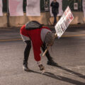 A protester writes with chalk outside the Hennepin County courthouse at the start of the Derek Chauvin murder trial.