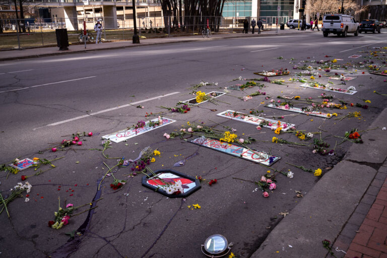 Protesters with mirrors and flowers outside Chauvin trial 2 Protesters place mirrors and red paint on the road outside the courthouse.