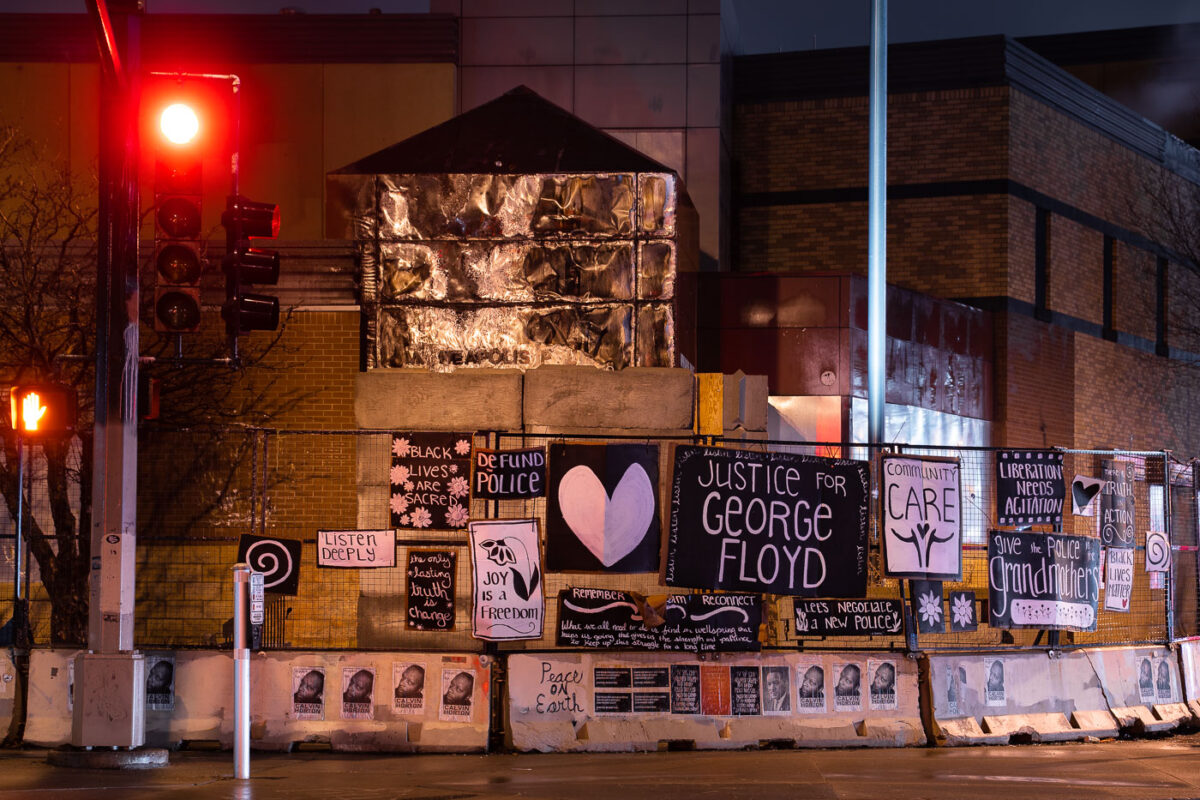 Protest signs hang on the former Minneapolis Police Third Precinct. The precinct was burned during unrest over the May 25th death of George Floyd.