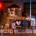 Protest signs hang on the former Minneapolis Police Third Precinct. The precinct was burned during unrest over the May 25th death of George Floyd.