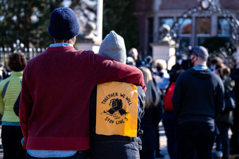 Together we will stop Line 3 3 Protesters with a Stop Line 3 protest sign in St. Paul.
