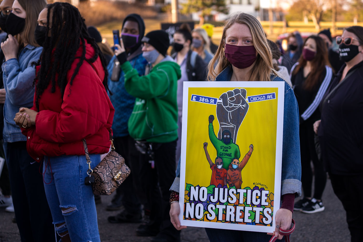 Woman holds up No Justice No Streets sign in St Paul