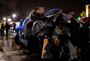 Protesters use umbrellas to shield themselves from chemical irritants being used by police outside the Brooklyn Center Police Department. Protesters are protesting the shooting death of 20-year old Daunte Wright on April 11th, 2021.