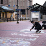 A couple walked by and picked up chalk to help finish a Black Lives Matter mural during the Derek Chauvin murder trial.