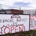 A sign for Hibachi Buffet in front of the burned Lake Street Station post office.