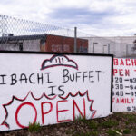 A sign for Hibachi Buffet in front of the burned Lake Street Station post office.