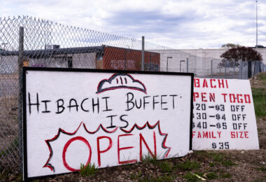 A sign for Hibachi Buffet in front of the burned Lake Street Station post office.