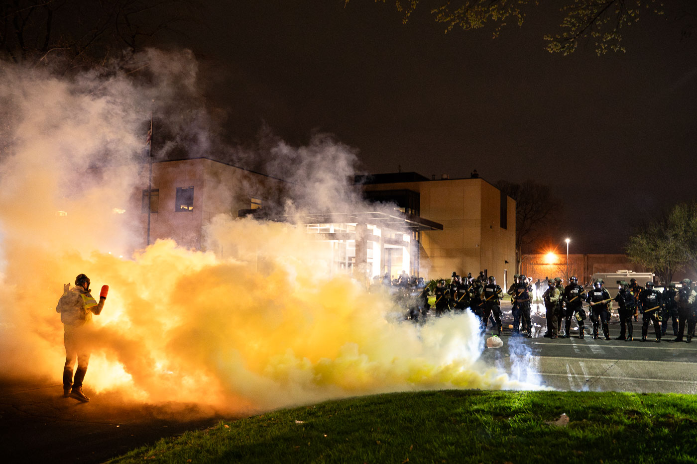 Protester stands in middle of tear gas