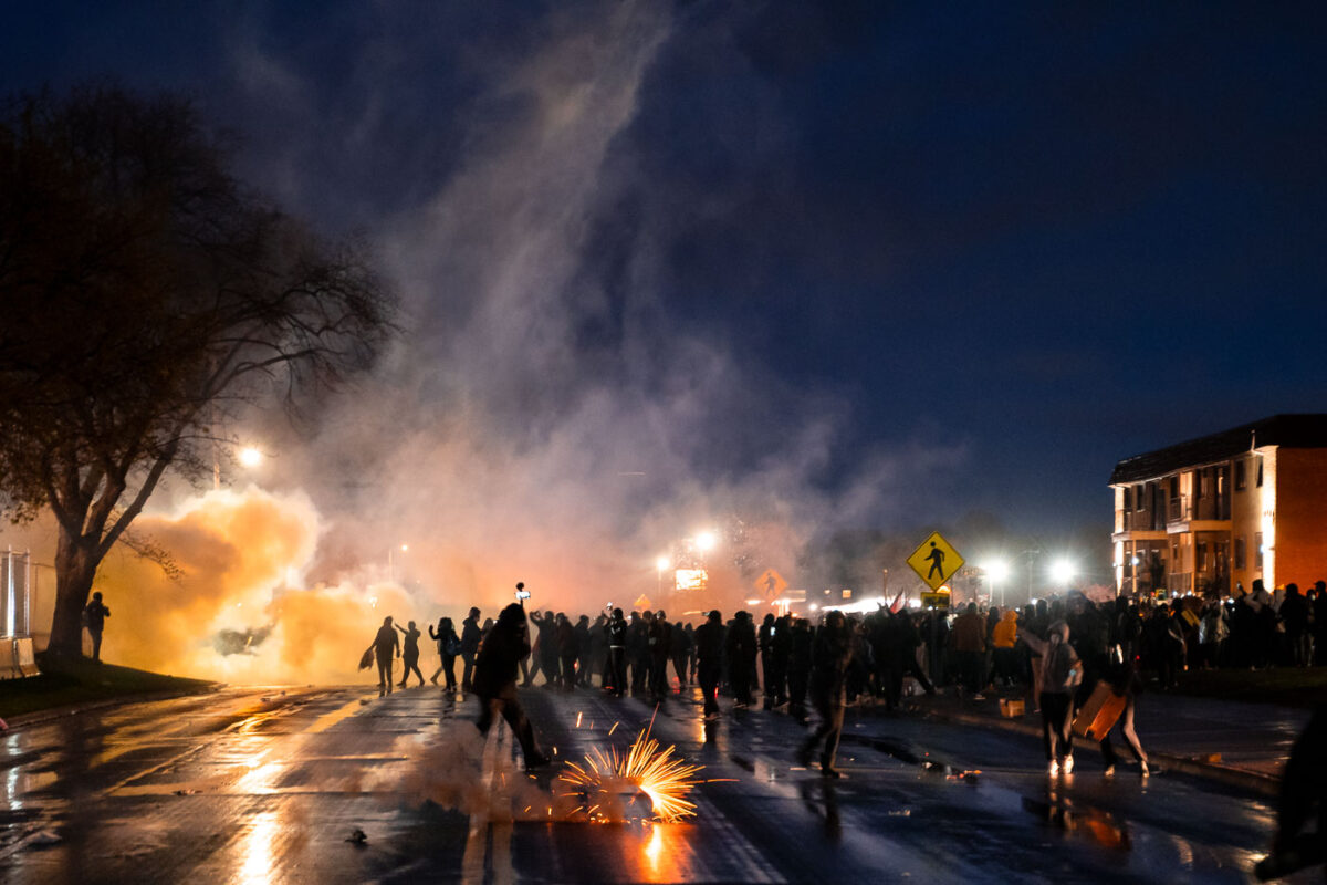 Police fire less lethal munitions and tear gas at protesters who gathered in front of the station.