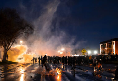 Police fire less lethal munitions and tear gas at protesters who gathered in front of the station.