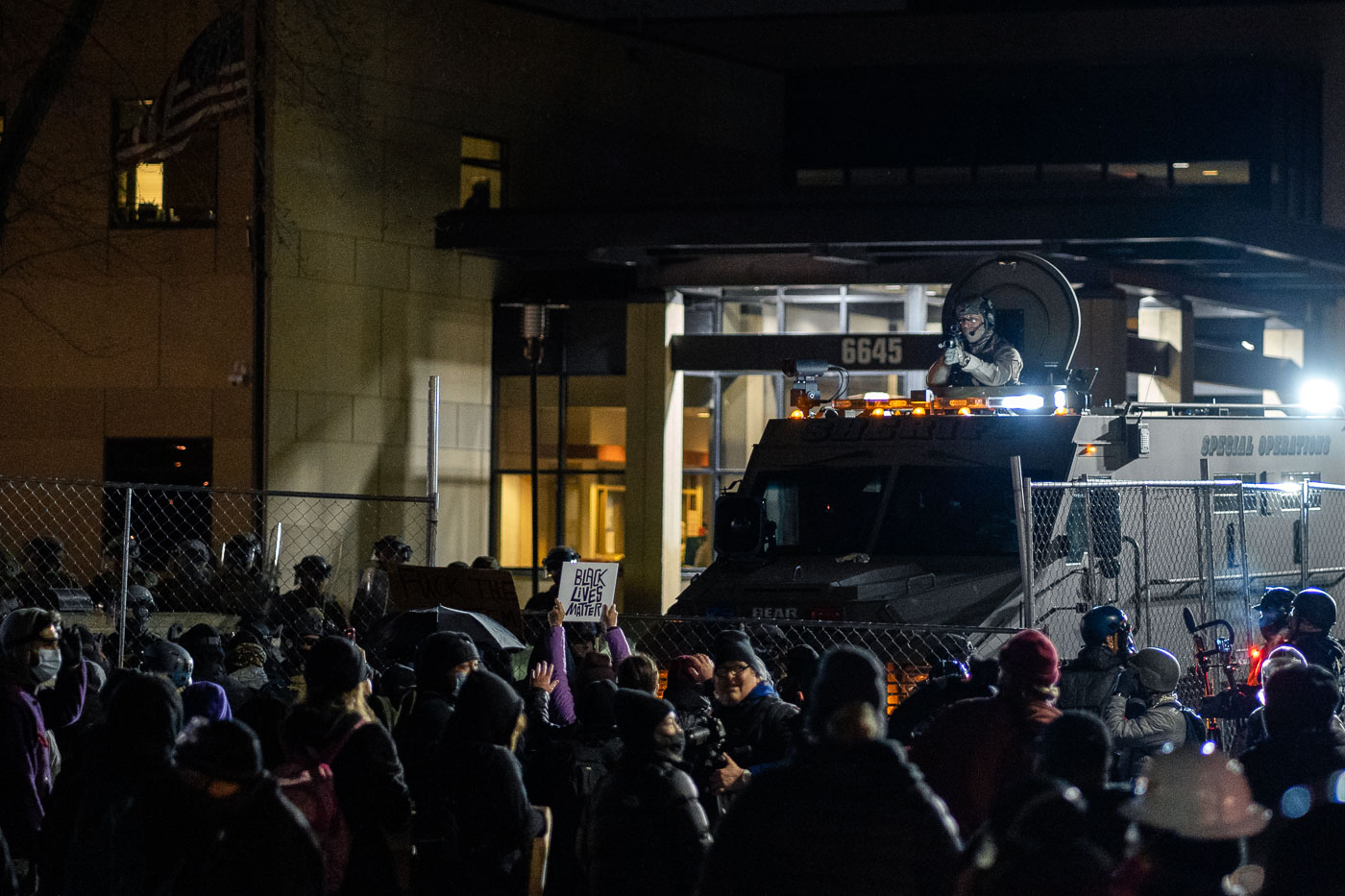 Protesters and tactical law enforcement vehicles