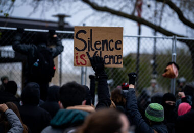 Protesters hold up signs outside the Brooklyn Center Police Department after officer Kim Potter shot and killed Daunte Wright.