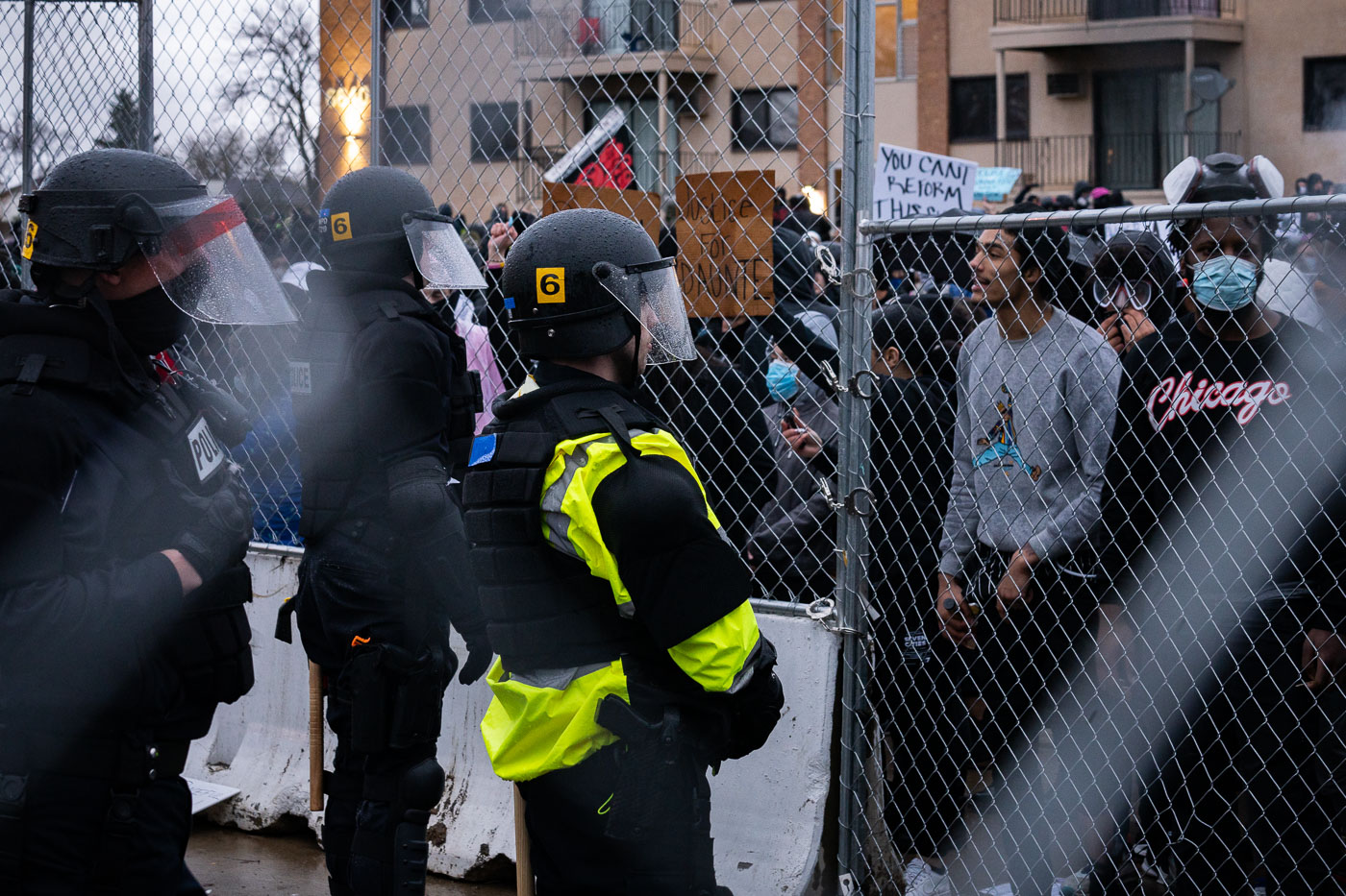 Protesters yell at police through fence in Brooklyn Center