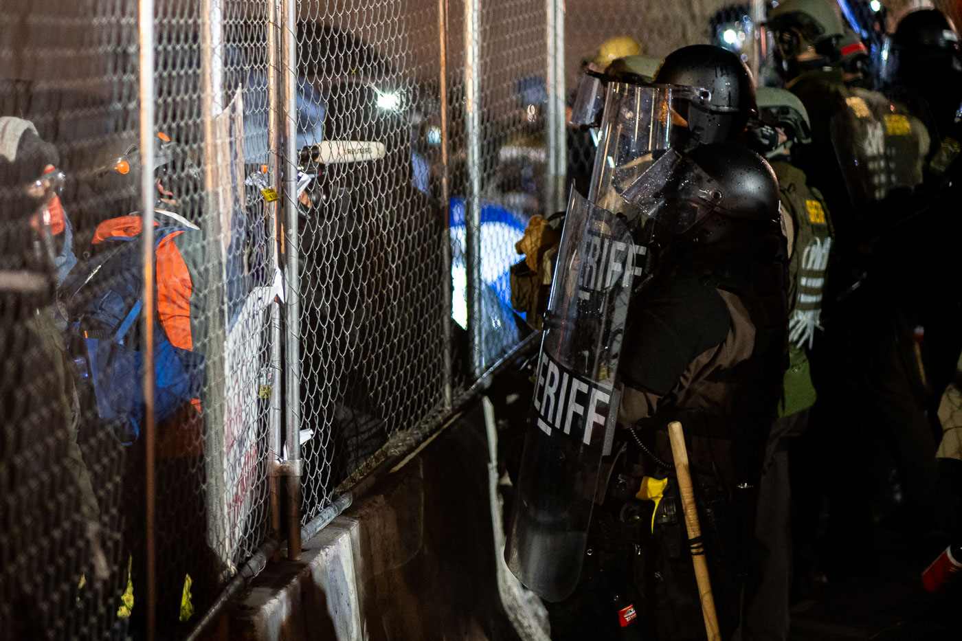 Sheriff officers and protesters at the fence