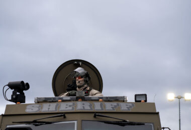 An officer with the Sheriff's department looks out at protesters at the Brooklyn Center Police Department.
