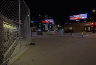 FOX9 billboards in downtown Minneapolis. US Bank Stadium to the left behind security fencing.