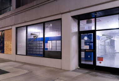 Boarded up and broken windows at the USPS Loop Station in downtown Minneapolis.