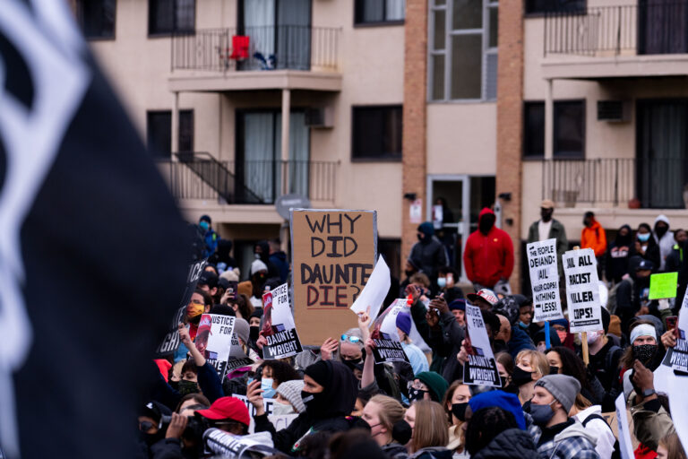 Why Did Daunte Die protest sign 2 Protesters outside the Brooklyn Center Police Department, where residential apartments are directly across the street.