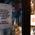 A sign welcoming everyone posted on the front door of Urban Outfitters in Uptown Minneapolis.