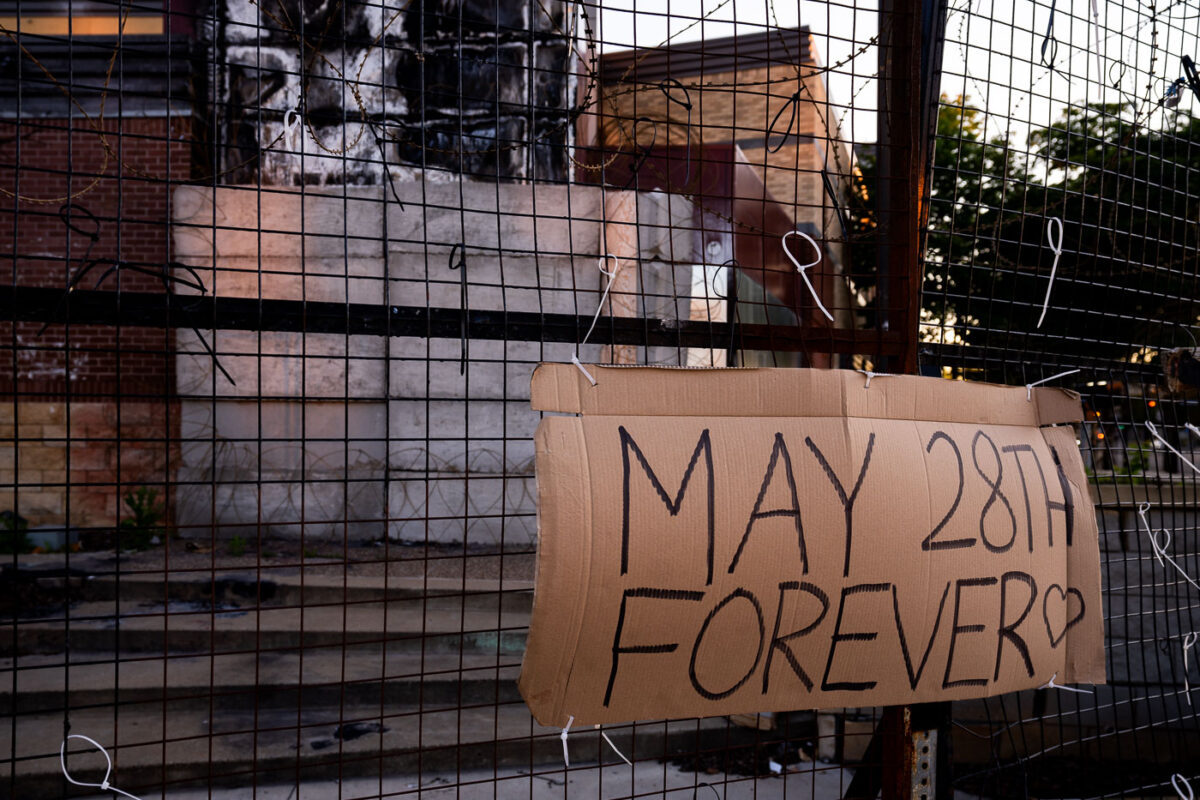 A "May 28th Forever" sign hangs on the third precinct on the 1 year anniversary of it burning.