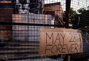 A "May 28th Forever" sign hangs on the third precinct on the 1 year anniversary of it burning.