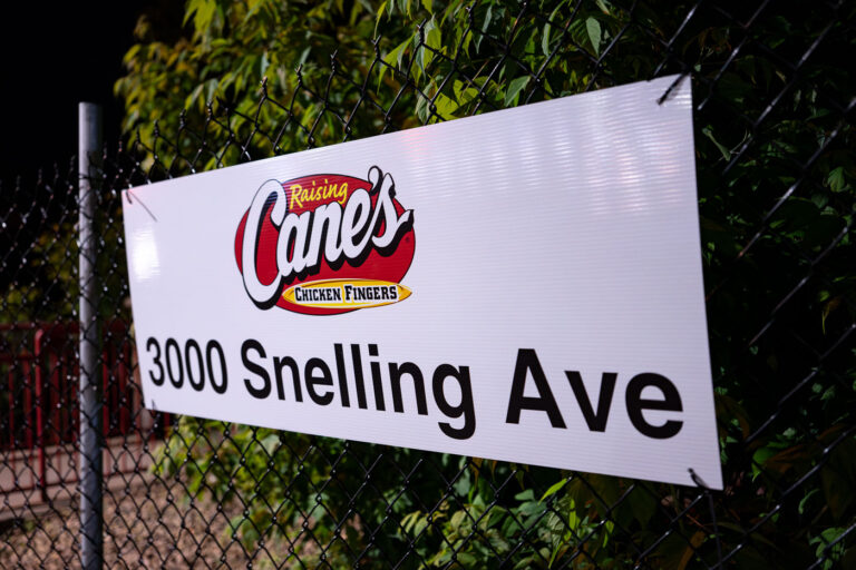 Raising Cane's Now Open Sign 1 A sign on a fence at a newly opened Raising Cane's Chicken Fingers restaurant in Minneapolis. It replaces an Arby's that was burned down following the murder of George Floyd.