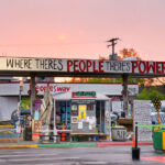 The sun sets behind The Peoples Way at George Floyd Square.