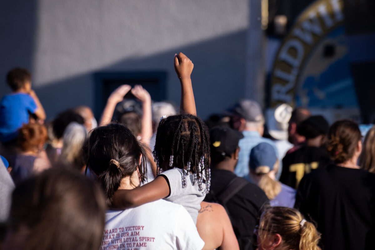 A child raises her fist during a performance of Common at George Floyd Square during Rise and Remember 2021.