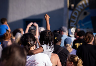 A child raises her fist during a performance of Common at George Floyd Square during Rise and Remember 2021.