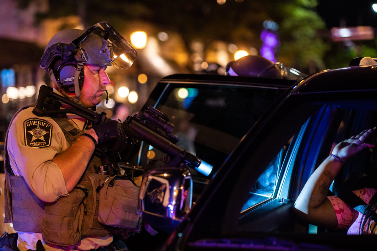 Hennepin County Sheriff officer points his weapon at someone inside a vehicle near Winston Smith protests. Smith was killed by law enforcement days earlier.