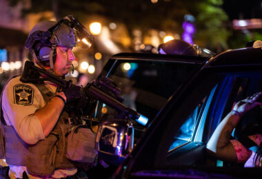 Hennepin County Sheriff officer points his weapon at someone inside a vehicle near Winston Smith protests. Smith was killed by law enforcement days earlier.