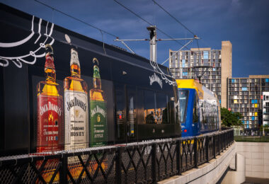 A Jack Daniel's wrapped light rail train in Minneapolis, Minnesota. Cedar Riverside apartments in the background.