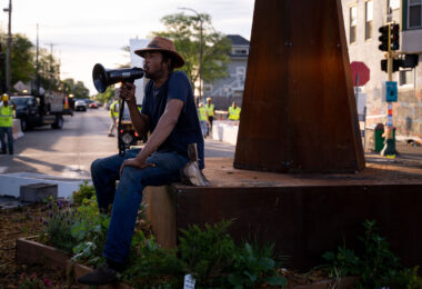 Jay Webb speaks at the garden in George Floyd Square while the city is opening the square to vehicle traffic.