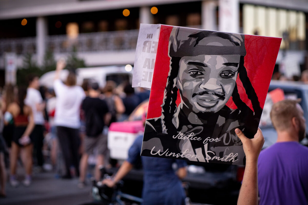 Protester holds up a Justice for Winston Smith sign on Lake Street during protests following the shooting death of Winston Smith on June 3rd by a Federal Task Force.

The day prior Deona Marie was killed when Nicholas Kraus drove his vehicle into those protesting the killing of Smith.