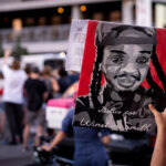 Justice for Winston Smith protest sign held up in Minneapolis 2 Protester holds up a Justice for Winston Smith sign on Lake Street during protests following the shooting death of Winston Smith on June 3rd by a Federal Task Force.The day prior Deona Marie was killed when Nicholas Kraus drove his vehicle into those protesting the killing of Smith.