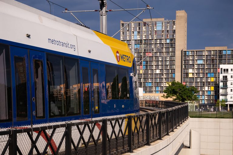 Metro Light Rail Approaching Cedar-Riverside Station 3 Metro Transit light rail train crossing I-35W near Cedar-Riverside Station with Riverside Plaza towers in the background.