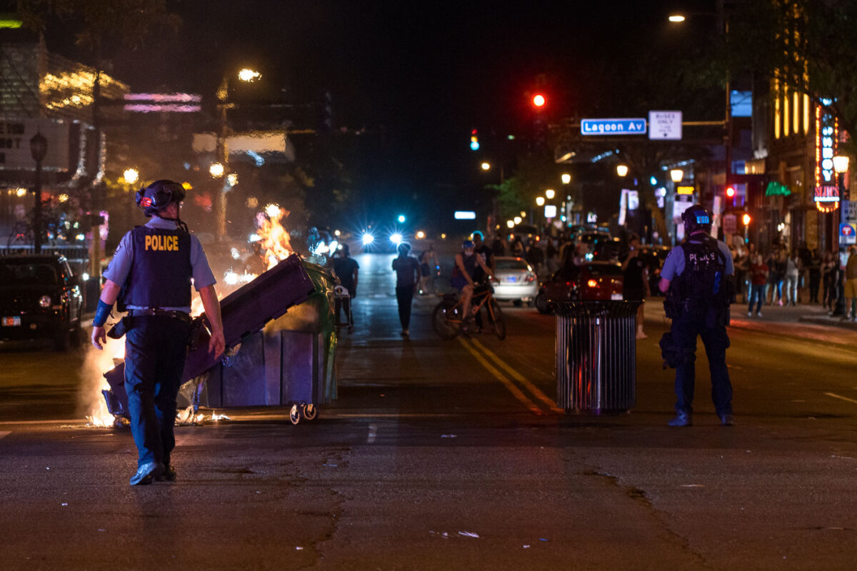 Garbage cans burn at Hennepin Avenue and Lake Street in Uptown Minneapolis during protests over the June 3rd law enforcement shooting death of Winston Smith.