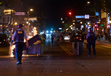 Garbage cans burn at Hennepin Avenue and Lake Street in Uptown Minneapolis during protests over the June 3rd law enforcement shooting death of Winston Smith.