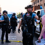 Minneapolis Police confront a woman while they clear out protesters and their barricades from Lake Street and Hennepin Avenue. Protesters have been gathered since the June 3rd and June 13th killings of Winston Smith and Deona Marie.Winston Smith was killed after Hennepin and Ramsey County officers fired their weapons while part of a Federal Task Force serving a warrant. Deona Marie was killed when Nicholas Kraus drove his vehicle into those protesting the killing of Smith.