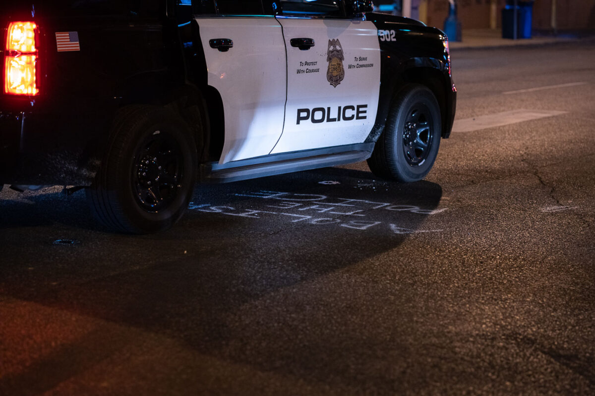 A Minneapolis Police squad car drives over "Abolish The Police" graffiti on Lake Street in Uptown Minneapolis.