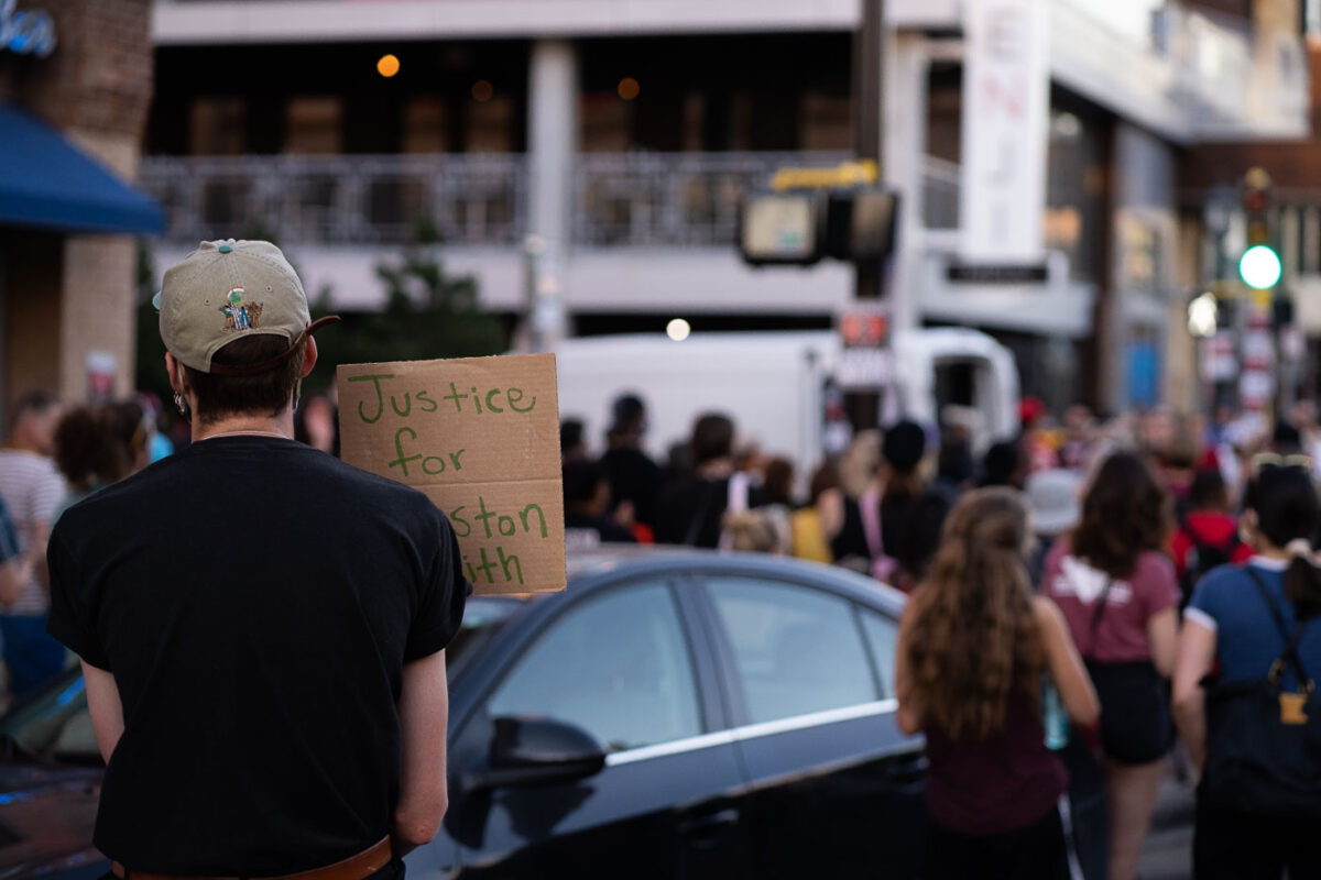 A protester holding a sign reading "Justice for Winston Smith". This follows a march around the neigbborhood after Deona Marie was killed

Marie was killed when Nicholas Kraus drove his vehicle into those protesting the June 3rd law enforcement killing of Smith.