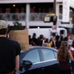 A protester holding a sign reading "Justice for Winston Smith". This follows a march around the neigbborhood after Deona Marie was killedMarie was killed when Nicholas Kraus drove his vehicle into those protesting the June 3rd law enforcement killing of Smith.