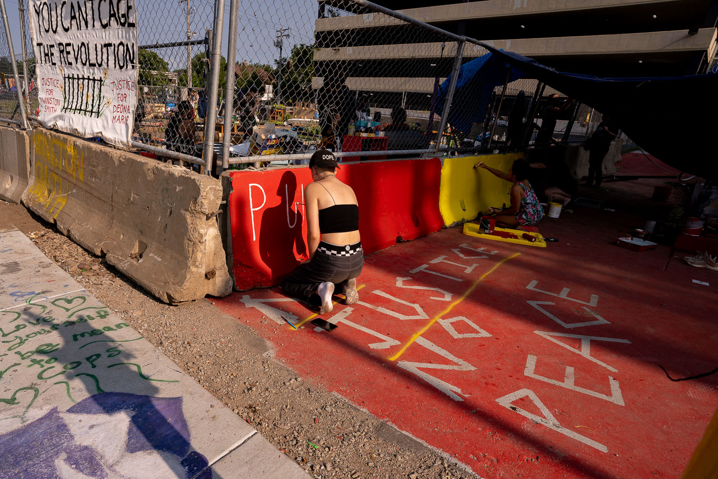 Protester writes on barricades in Uptown Minneapolis