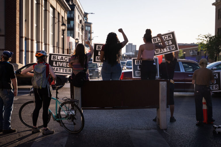 Protesters hold up Black Lives Matter signs in Minneapolis 1 Protesters holding up Black Lives Matter signs on Lake Street at Hennepin Avenue with barricades in place. Protesters have been protesting the June 3rd law enforcement killing of Winston Smith and the June 13th killing of Deona Marie.
Marie was killed when Nicholas Kraus drove his vehicle into those protesting the killing of Smith.